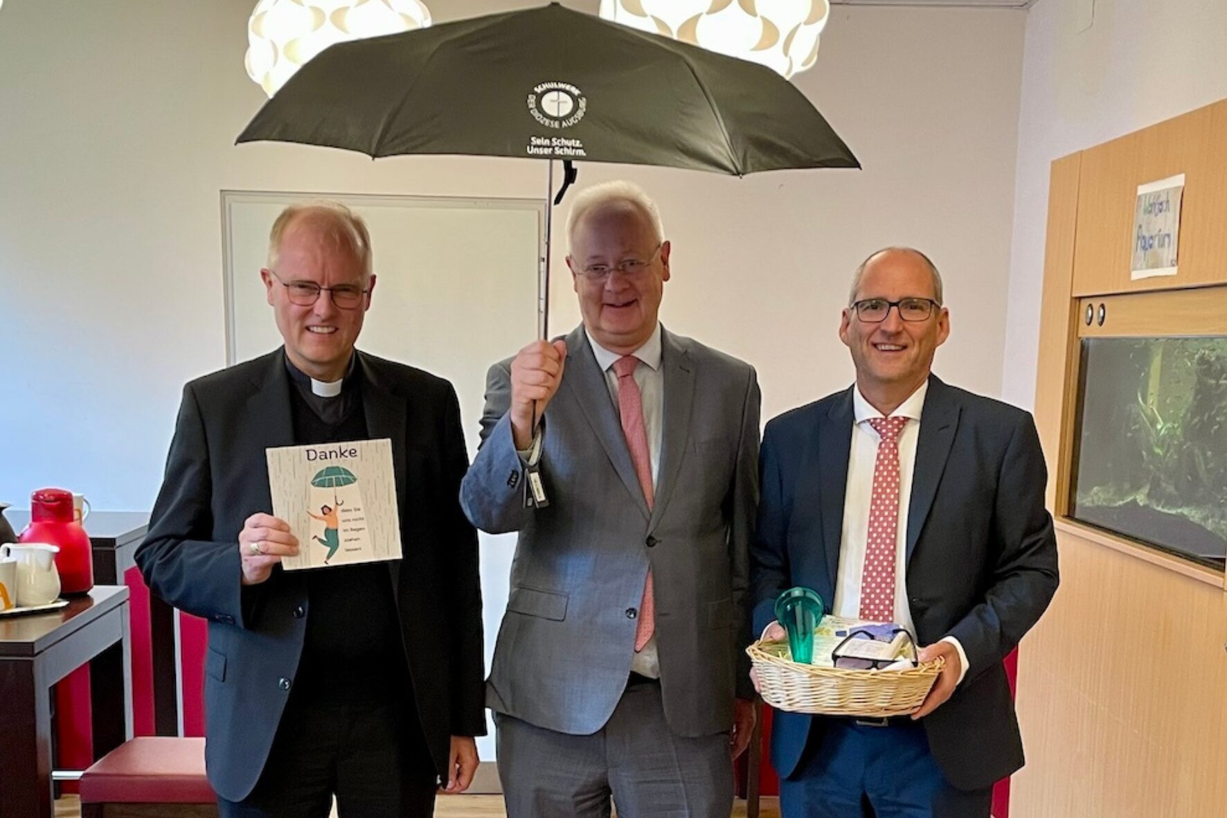 Weihbischof Florian Wörner, Direktor Peter Kosak und MdL mit Schirm des Schulwerks der Diözese Augsburg