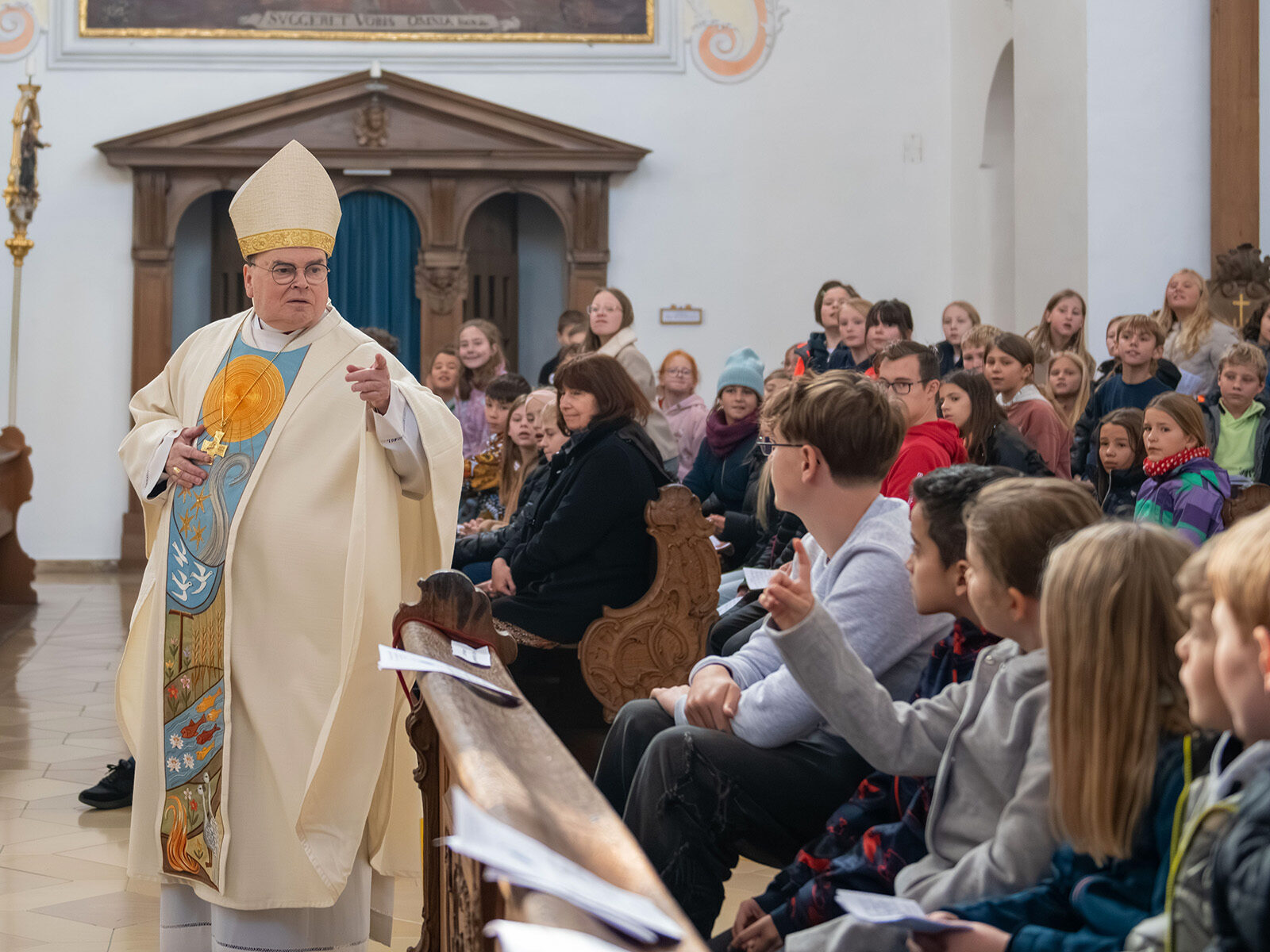Bischof Bertram Meier spricht zu Schülerinnen und Schülern in der Basilika St. Peter, Dillingen