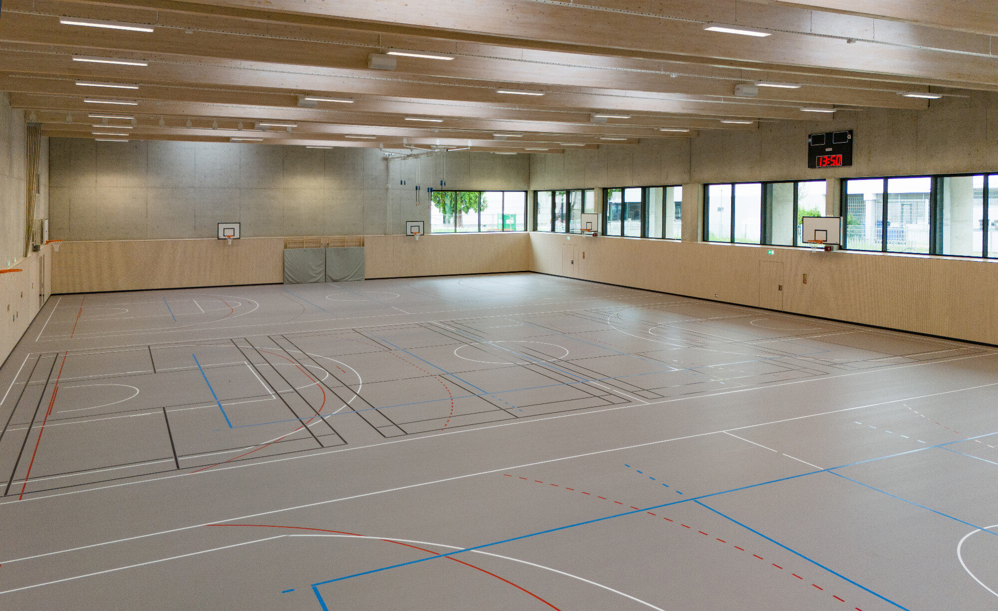 Neue Dreifachturnhalle mit Holzbalken und Sportboden im Bona-Campus Dillingen