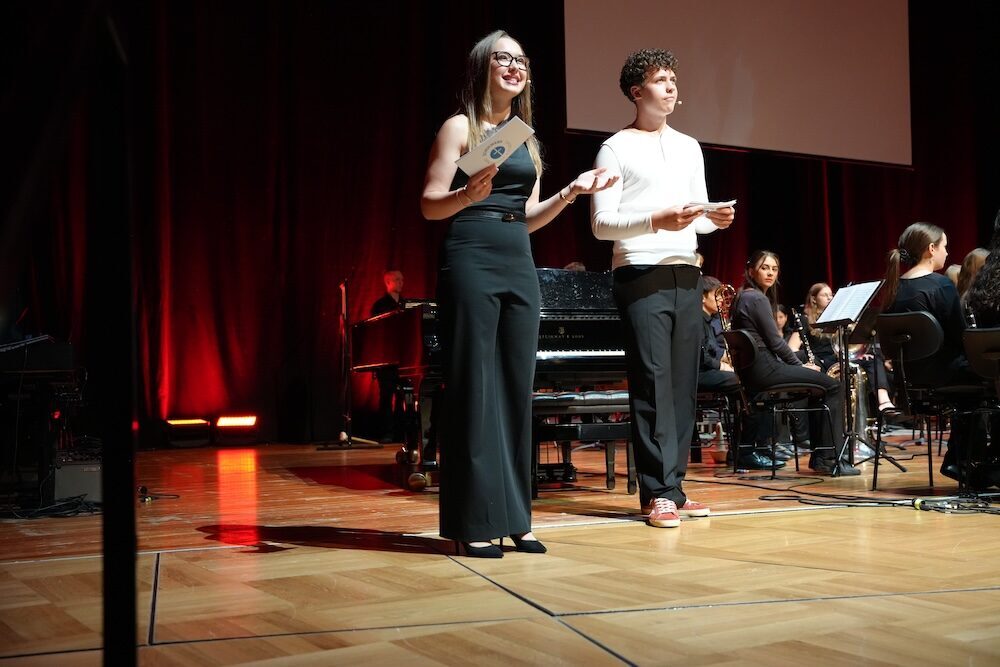 Moderatorin und Moderator vor Orchester und Flügel, Best of Schulwerk 2026