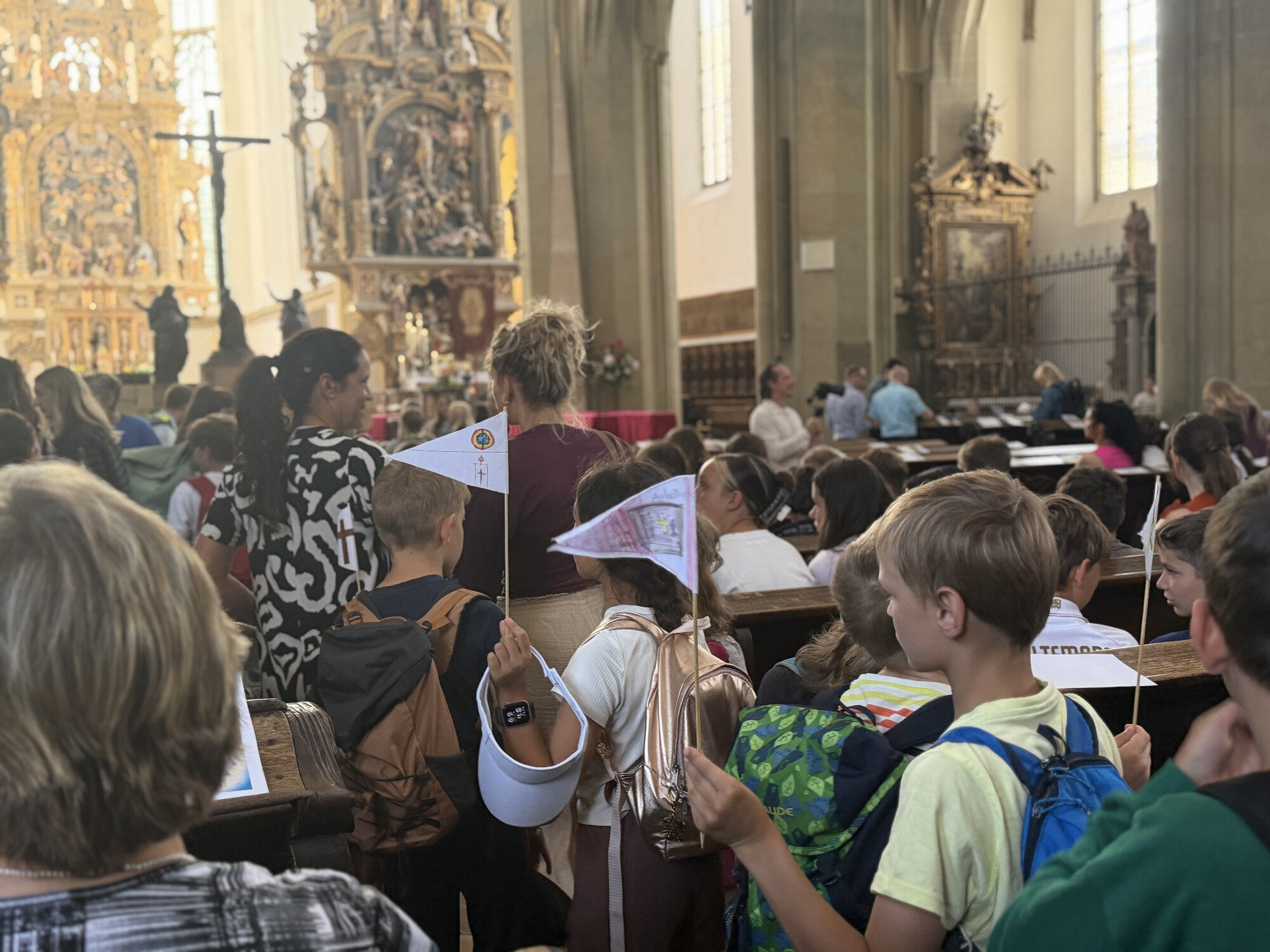 Schülerinnen und Schüler in den Kirchenbänken beim Pontifikalamt der Ulrichswoche in Augsburg