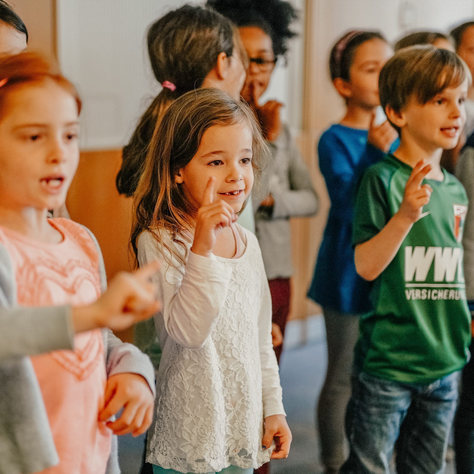 Schülerinnen und Schüler klatschen im Kreis, Gemeinschaft im Schulwerk Augsburg